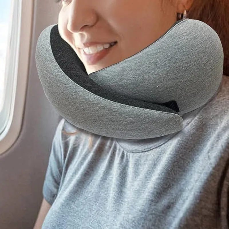 Navy blue U-shaped memory foam travel neck pillow rolled up next to its carry bag.