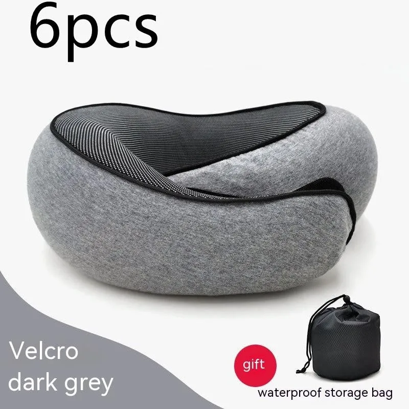 Navy blue U-shaped memory foam travel neck pillow rolled up next to its carry bag.