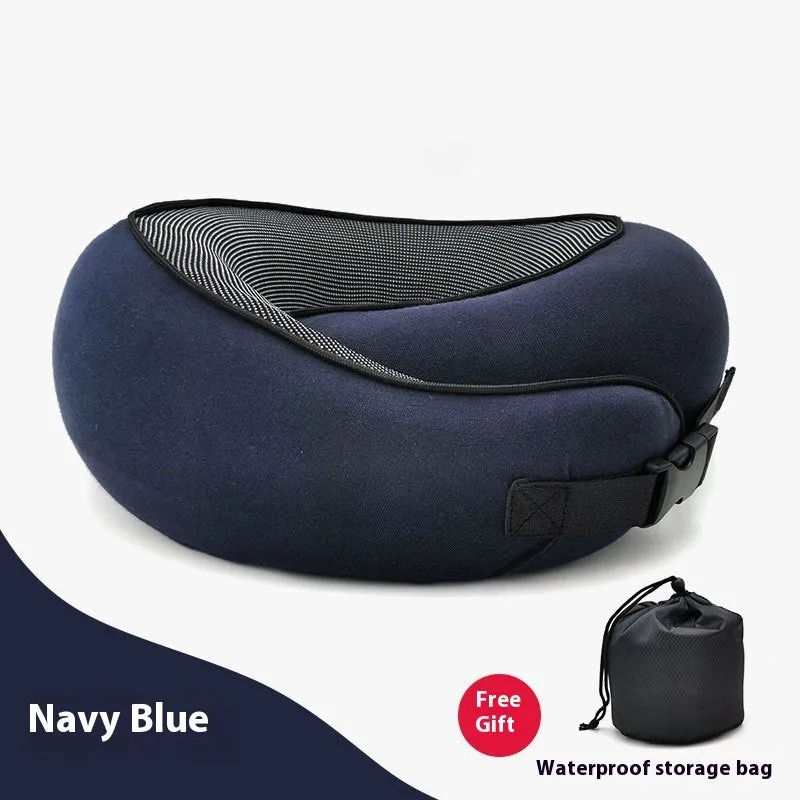Navy blue U-shaped memory foam travel neck pillow rolled up next to its carry bag.