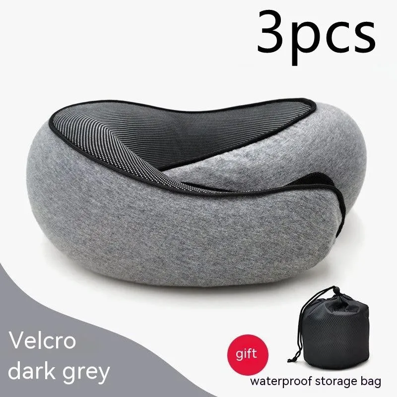 Navy blue U-shaped memory foam travel neck pillow rolled up next to its carry bag.