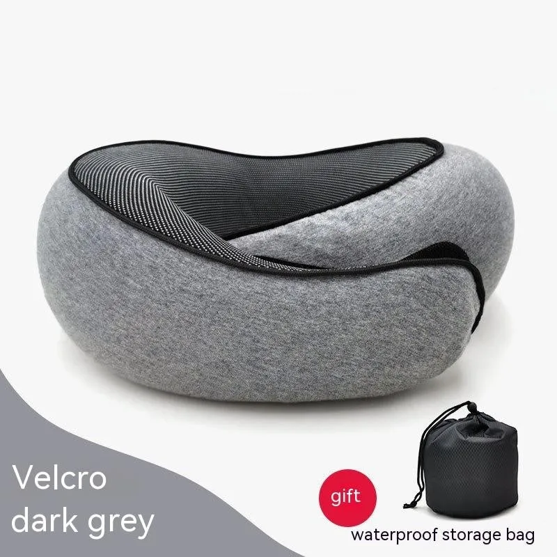 Navy blue U-shaped memory foam travel neck pillow rolled up next to its carry bag.