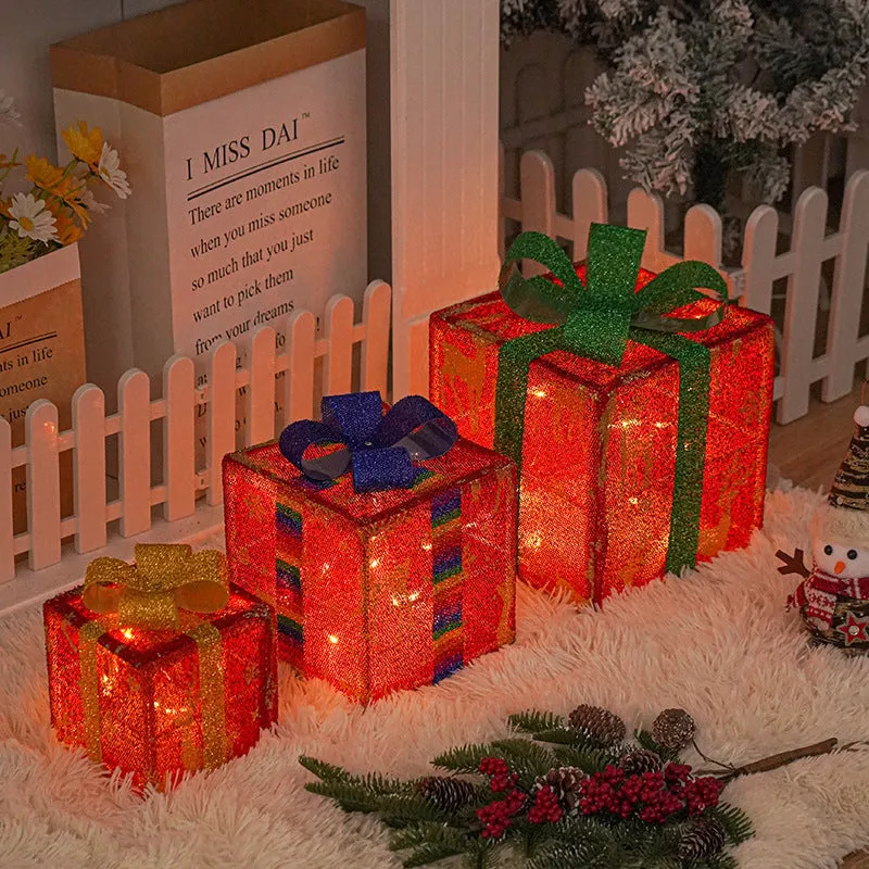 Set of three pre-lit Christmas gift box decorations with bows and LED lights for outdoor use.