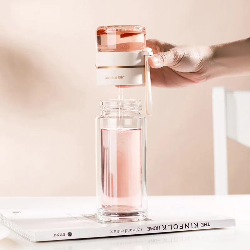 Green double-wall glass water bottle with a stainless steel tea infuser insert and a black leak-proof lid with rope handle.