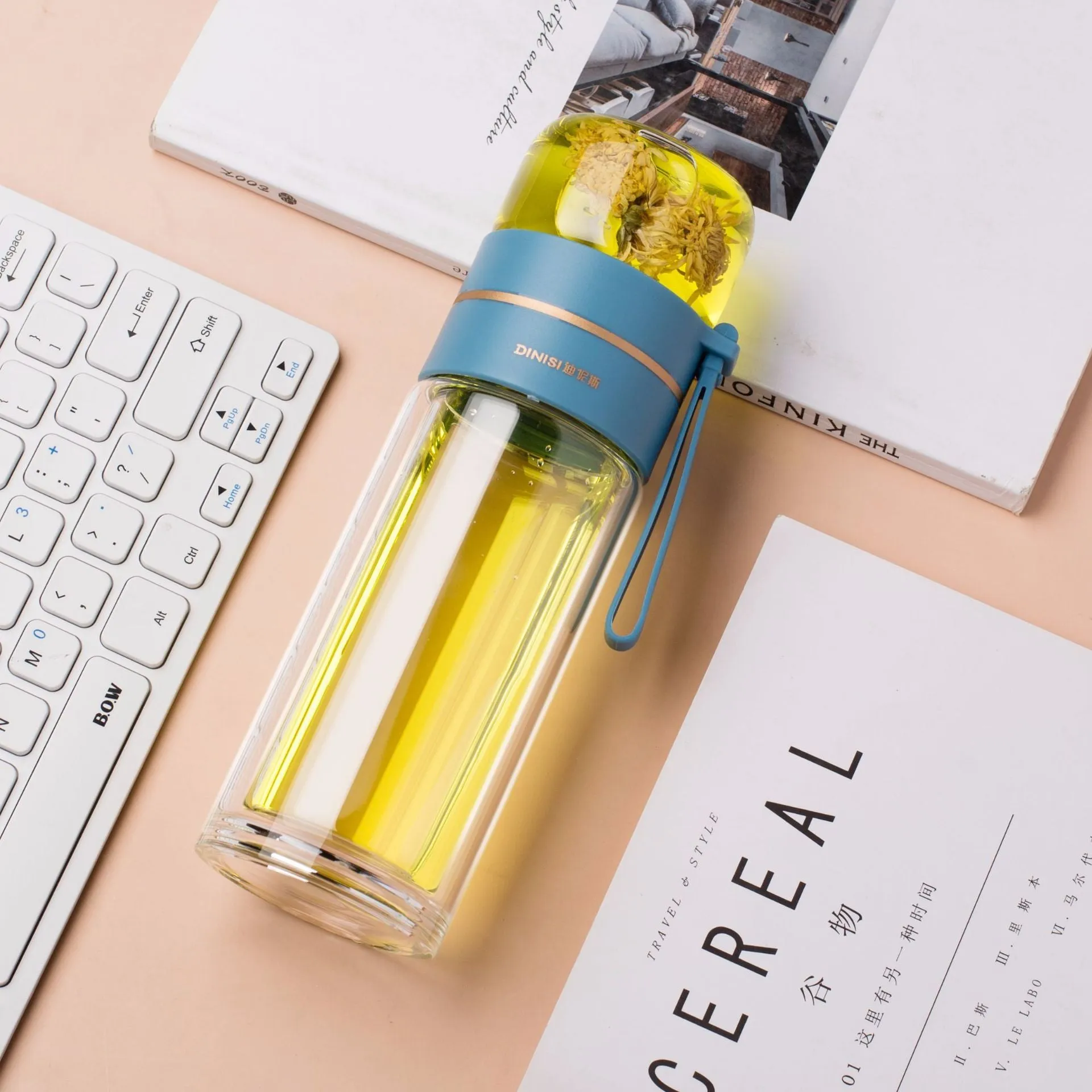 Green double-wall glass water bottle with a stainless steel tea infuser insert and a black leak-proof lid with rope handle.