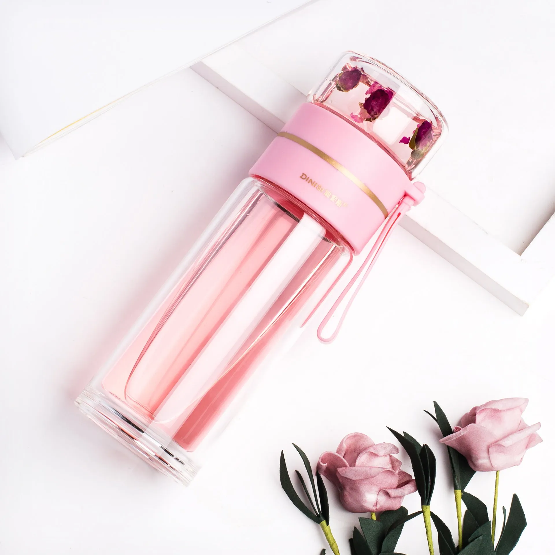 Green double-wall glass water bottle with a stainless steel tea infuser insert and a black leak-proof lid with rope handle.