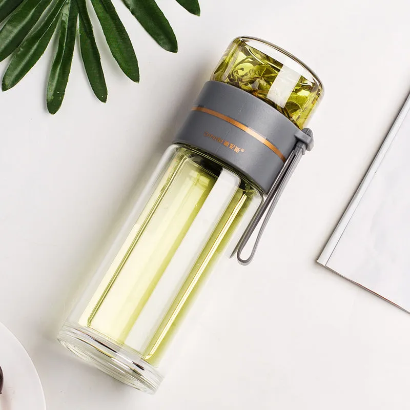 Green double-wall glass water bottle with a stainless steel tea infuser insert and a black leak-proof lid with rope handle.