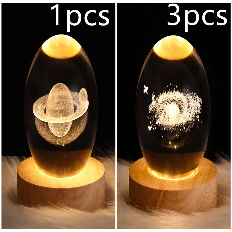 LED galaxy crystal ball night light with 3D planet designs on a table