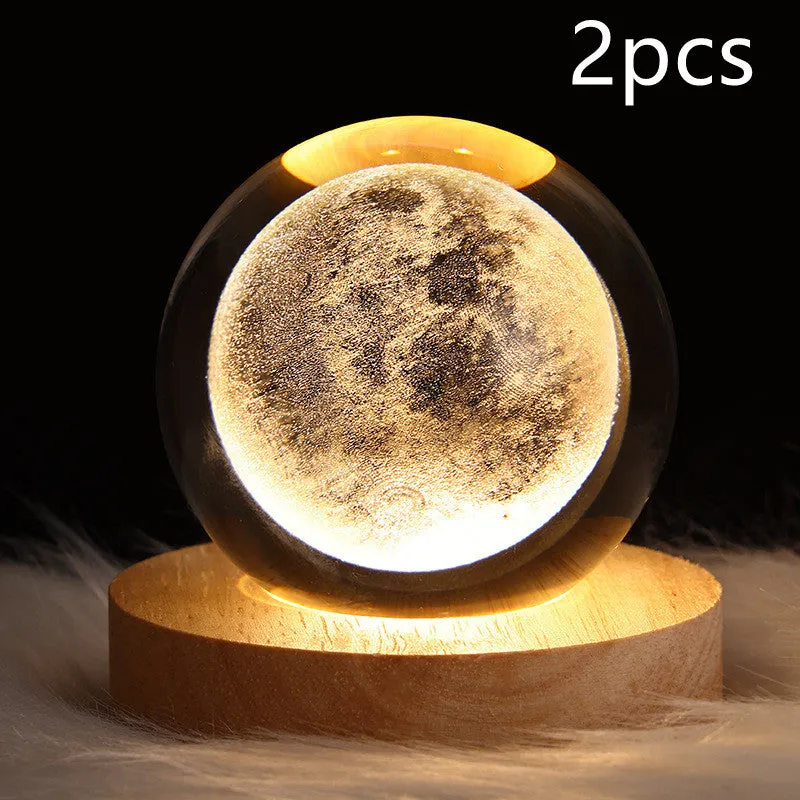 LED galaxy crystal ball night light with 3D planet designs on a table