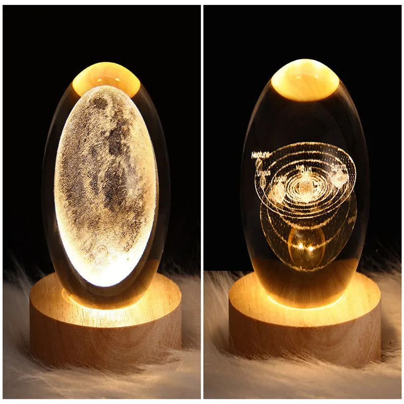 LED galaxy crystal ball night light with 3D planet designs on a table