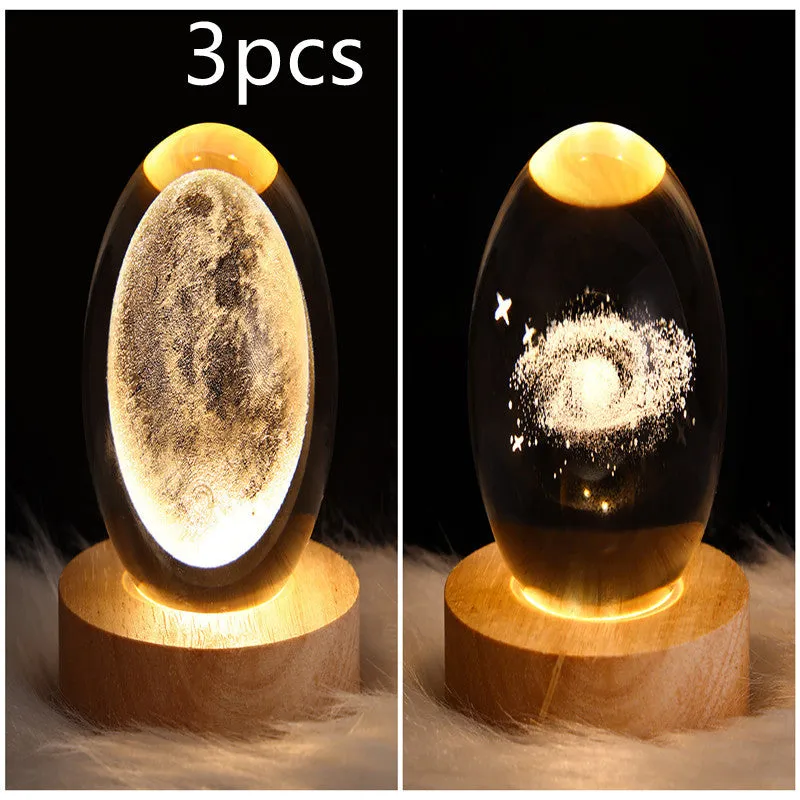 LED galaxy crystal ball night light with 3D planet designs on a table