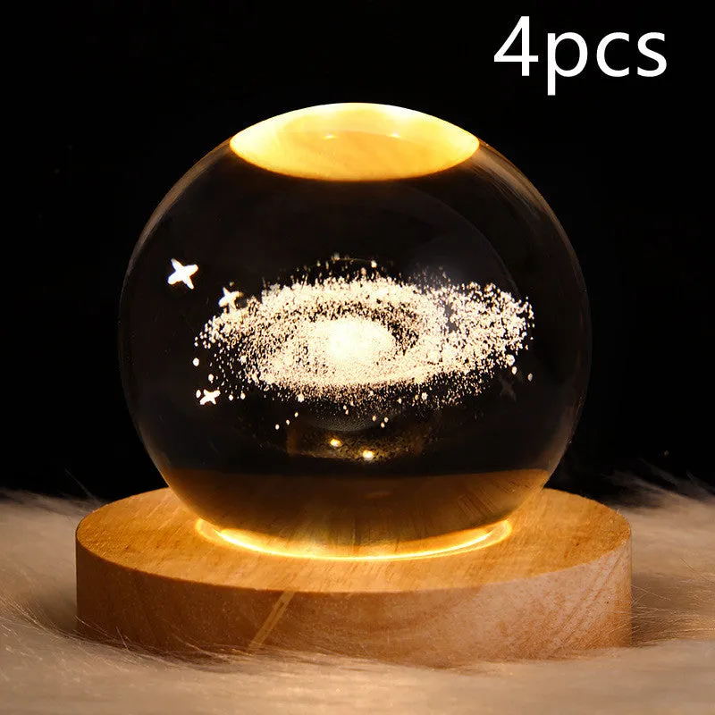 LED galaxy crystal ball night light with 3D planet designs on a table