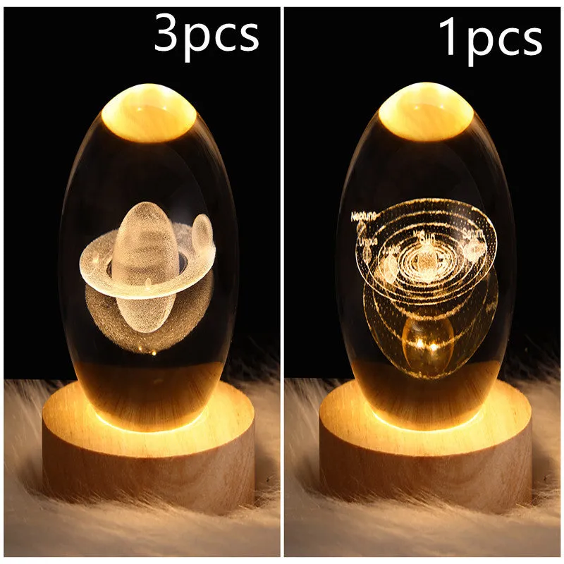 LED galaxy crystal ball night light with 3D planet designs on a table