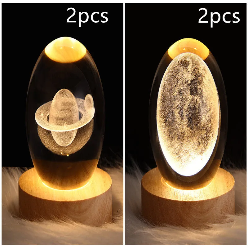 LED galaxy crystal ball night light with 3D planet designs on a table