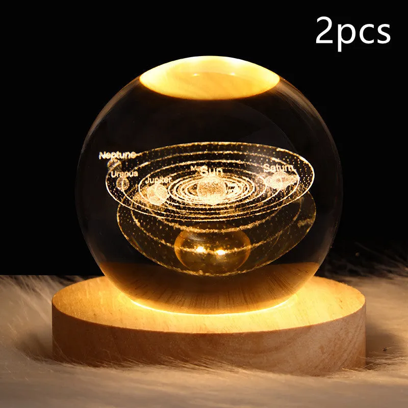 LED galaxy crystal ball night light with 3D planet designs on a table