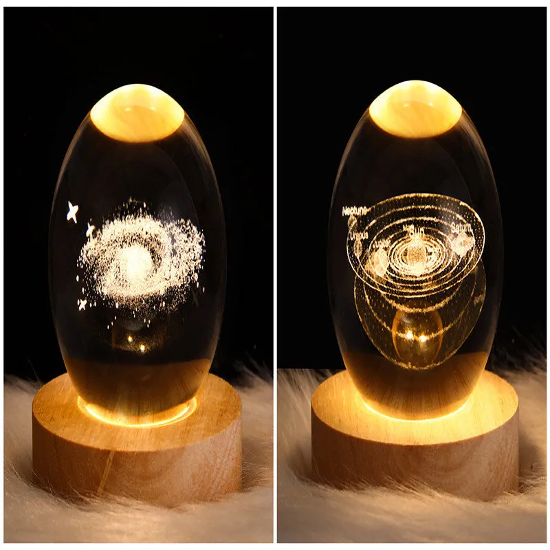 LED galaxy crystal ball night light with 3D planet designs on a table