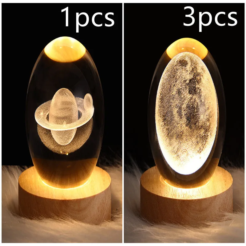 LED galaxy crystal ball night light with 3D planet designs on a table