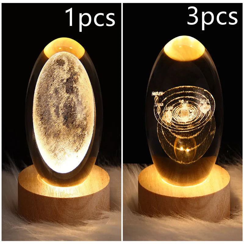 LED galaxy crystal ball night light with 3D planet designs on a table