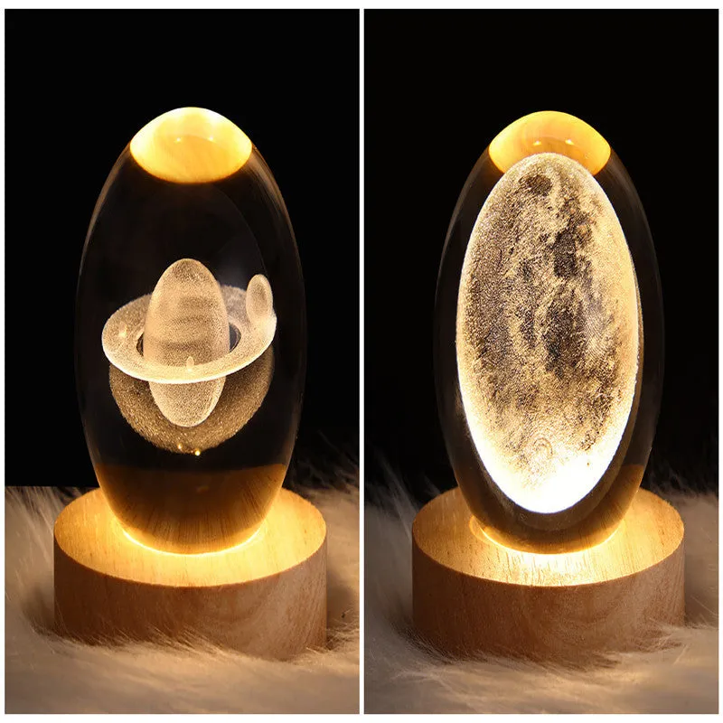 LED galaxy crystal ball night light with 3D planet designs on a table