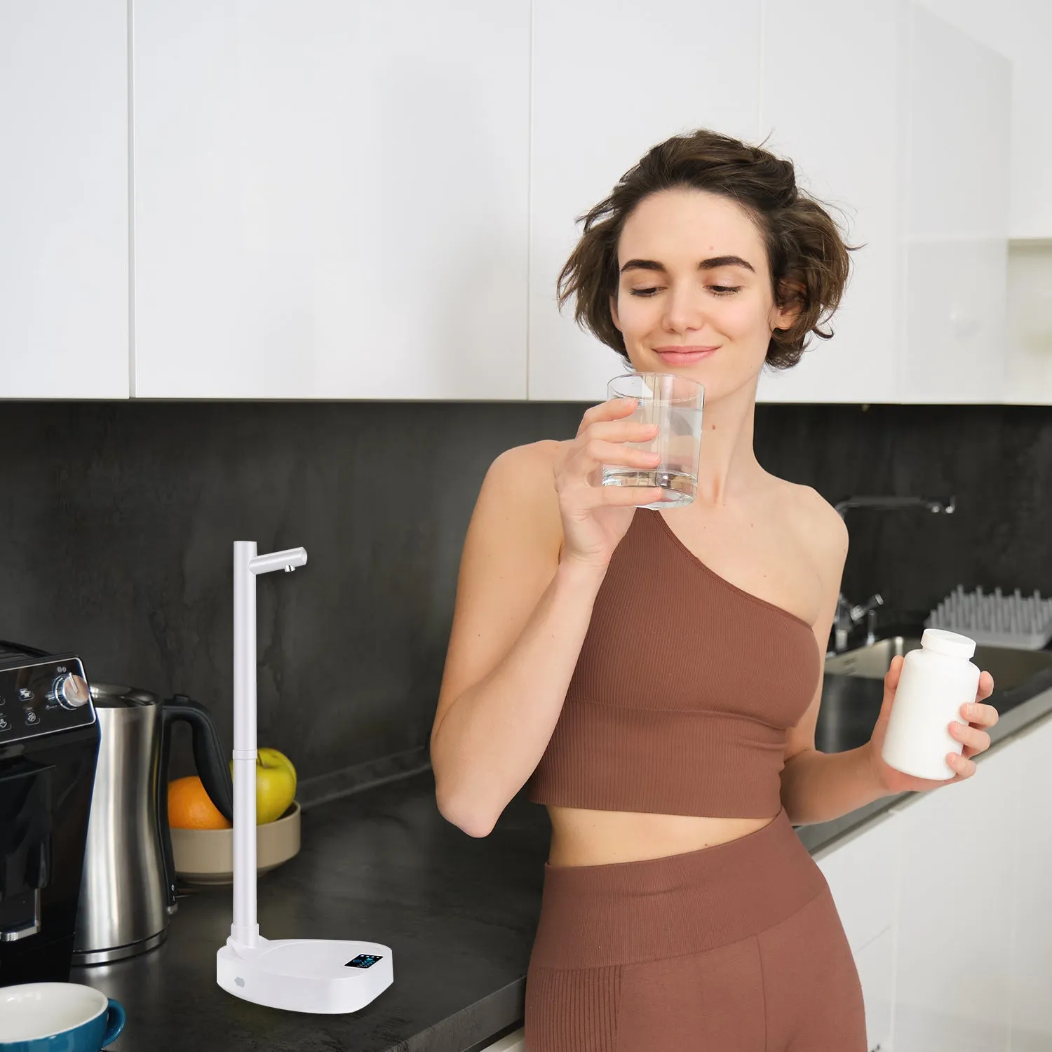 White and blue desktop water dispenser with extension tube on counter next to water bottle