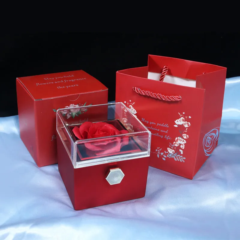 Rotating jewellery gift box with a preserved red rose under a clear acrylic dome.