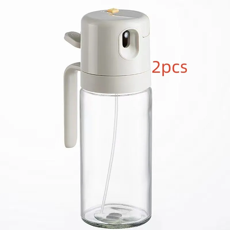 Warm grey glass 550ml oil sprayer bottle with a black spray head on a kitchen counter.