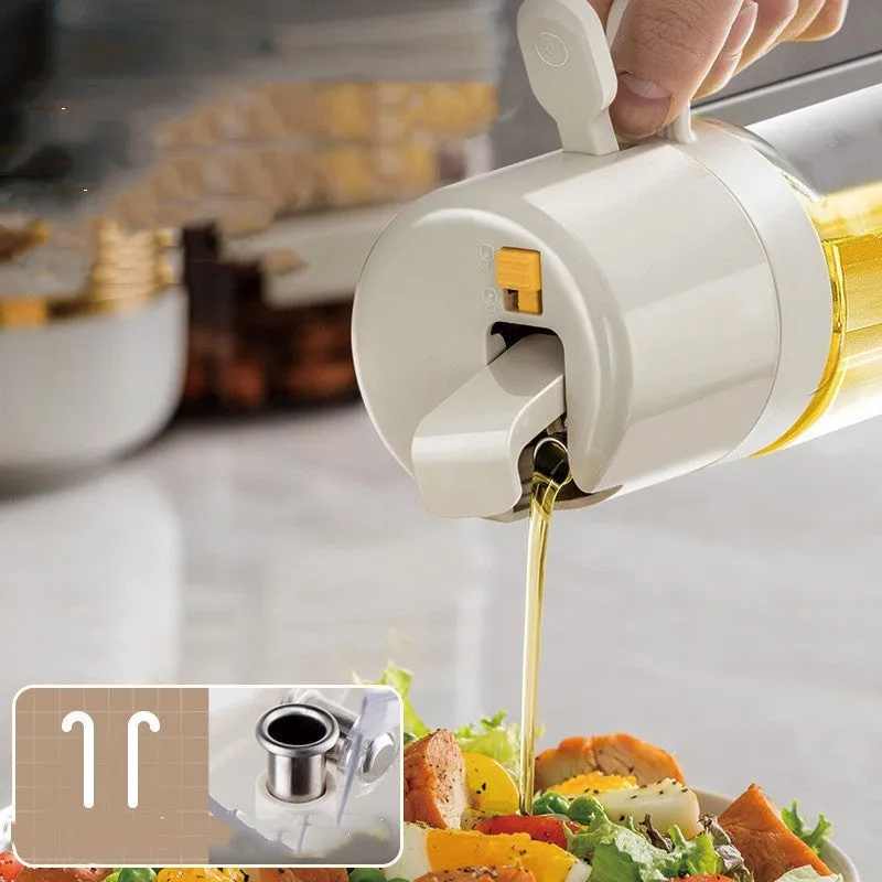 Warm grey glass 550ml oil sprayer bottle with a black spray head on a kitchen counter.