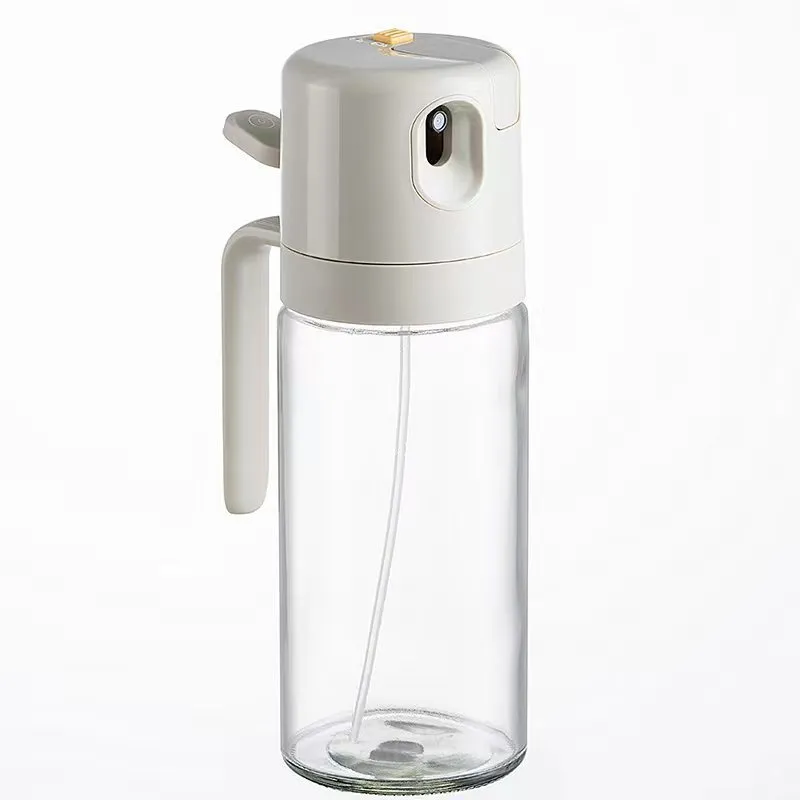 Warm grey glass 550ml oil sprayer bottle with a black spray head on a kitchen counter.