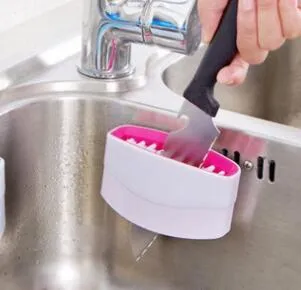 Blue kitchen cleaning brush with suction cup showing knife and fork design for washing fruits and vegetables