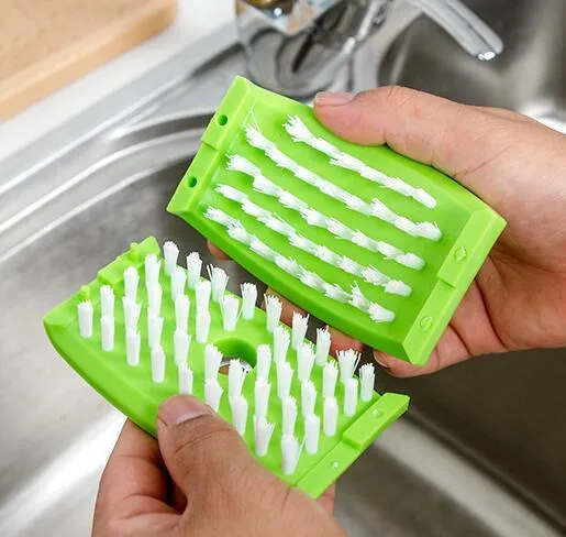 Blue kitchen cleaning brush with suction cup showing knife and fork design for washing fruits and vegetables