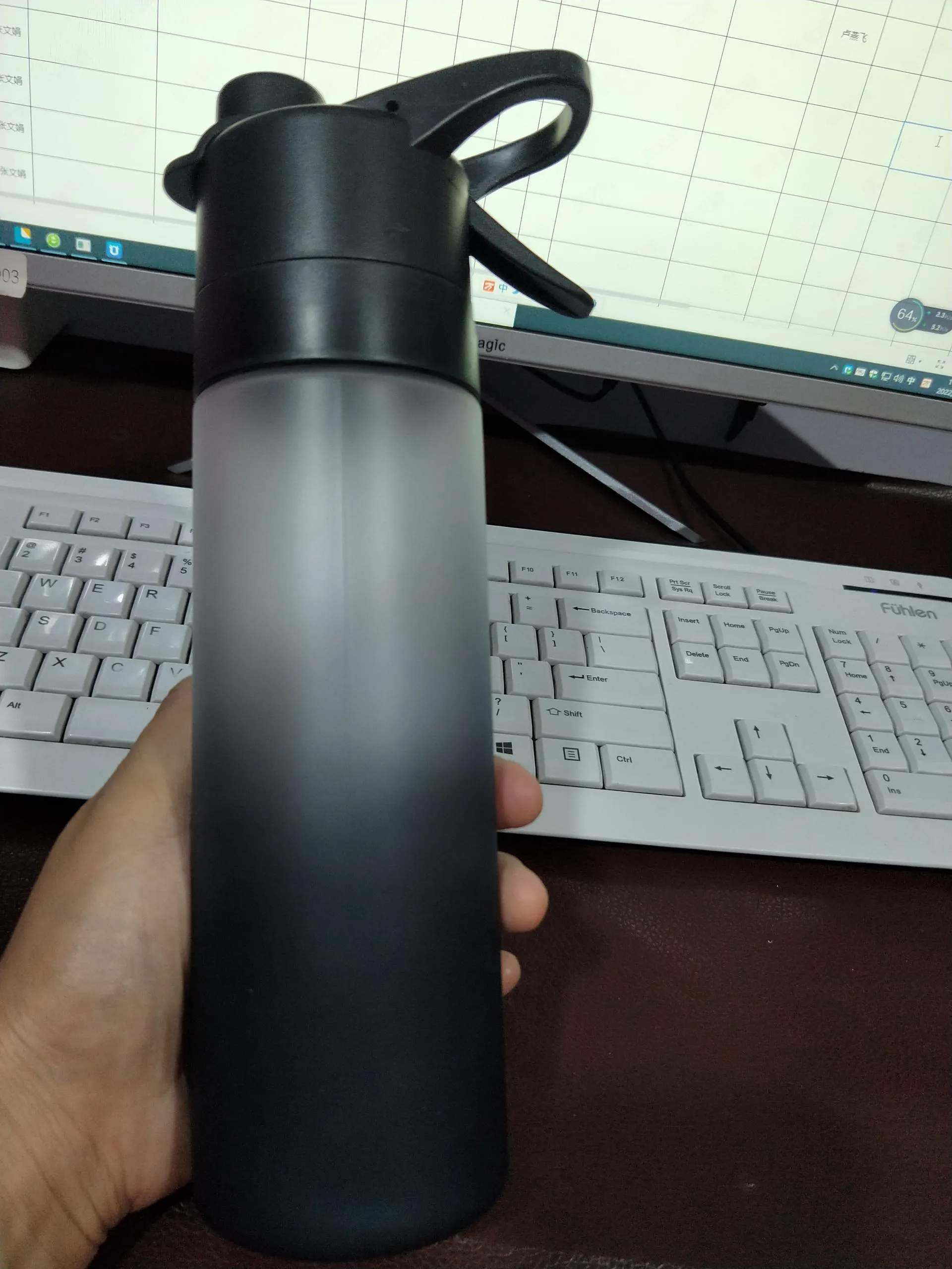 White 700ml plastic spray water bottle with handle strap and leakproof lid.