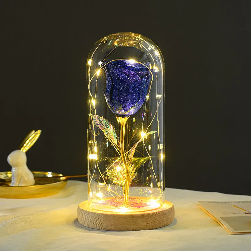 Glass dome covering a red eternal rose with coiled battery-powered LED lights on bendable copper wire.