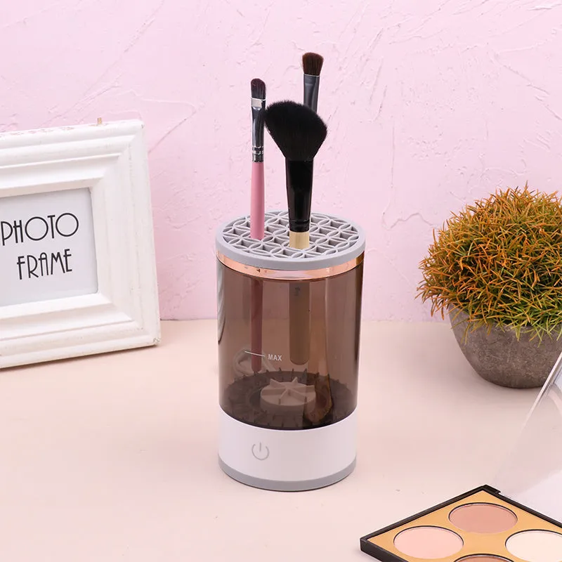 Grey and white portable electric makeup brush cleaner with USB cable.