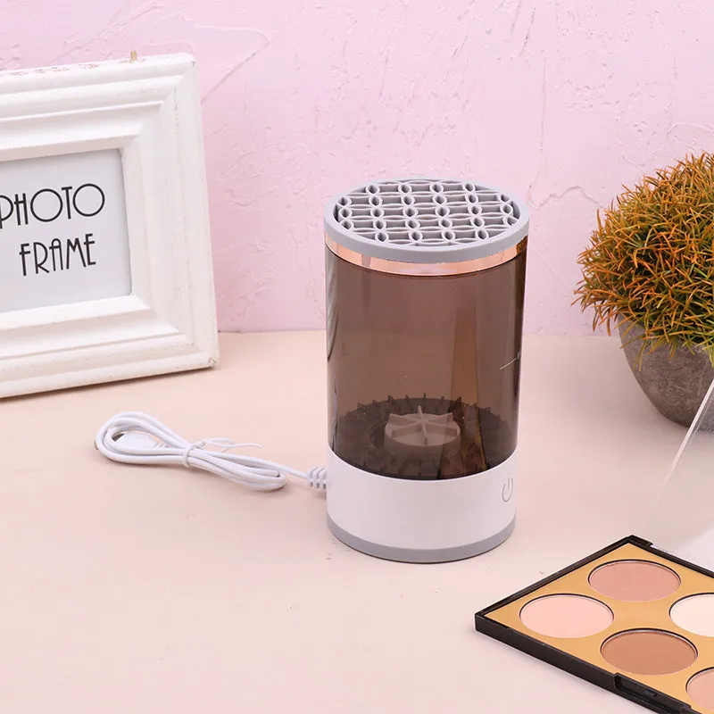 Grey and white portable electric makeup brush cleaner with USB cable.