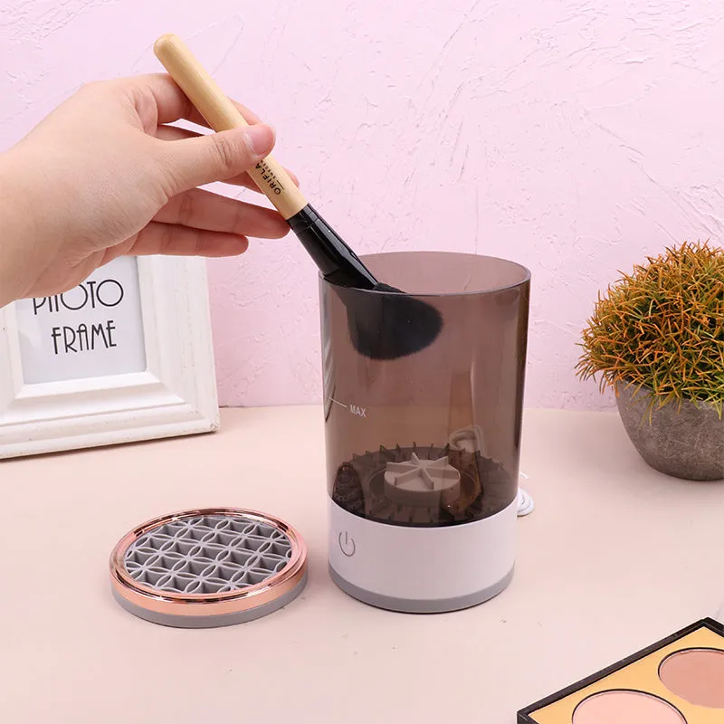 Grey and white portable electric makeup brush cleaner with USB cable.