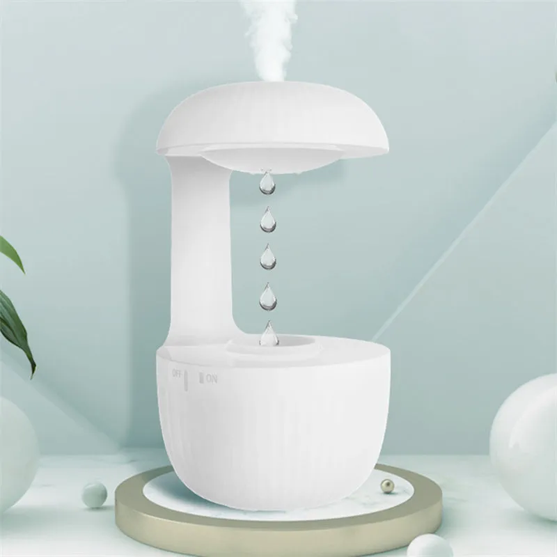 White anti-gravity humidifier showing water droplets levitating upwards from its mist outlet.