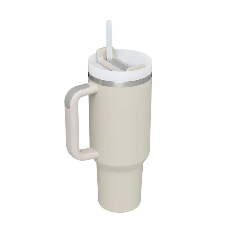40 oz stainless steel insulated tumbler with a black handle, straw, and grey lid on a wooden table