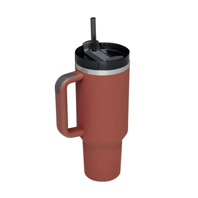 40 oz stainless steel insulated tumbler with a black handle, straw, and grey lid on a wooden table