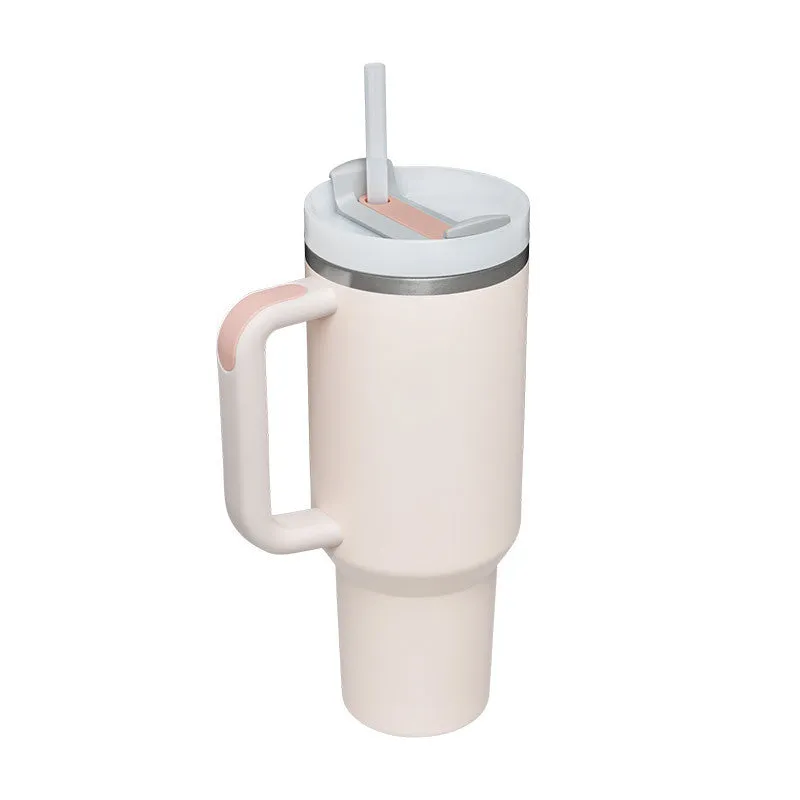 40 oz stainless steel insulated tumbler with a black handle, straw, and grey lid on a wooden table