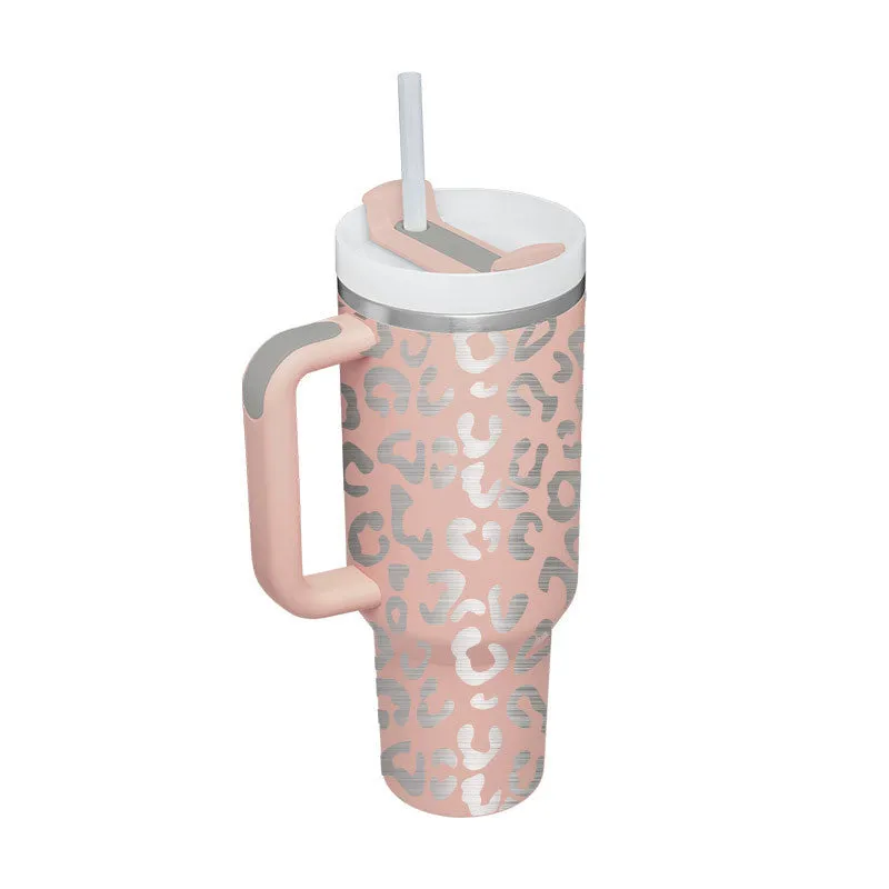 40 oz stainless steel insulated tumbler with a black handle, straw, and grey lid on a wooden table