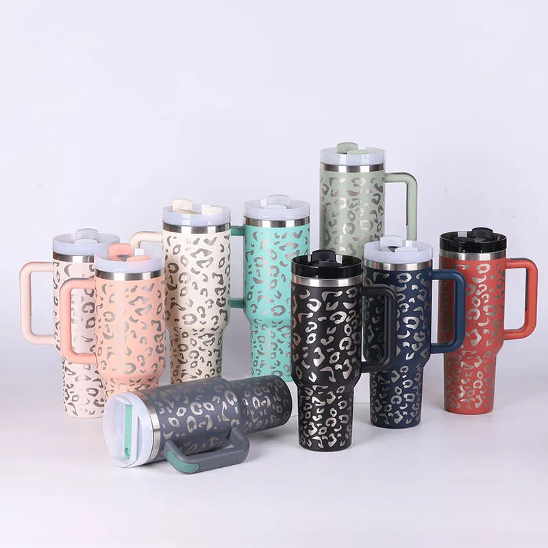 40 oz stainless steel insulated tumbler with a black handle, straw, and grey lid on a wooden table