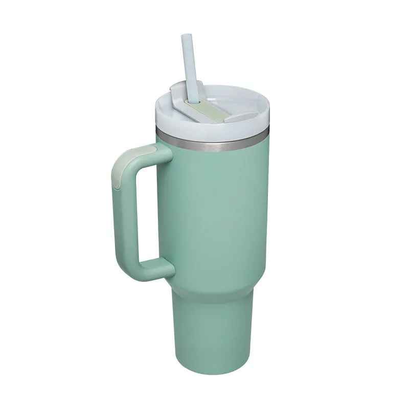 40 oz stainless steel insulated tumbler with a black handle, straw, and grey lid on a wooden table