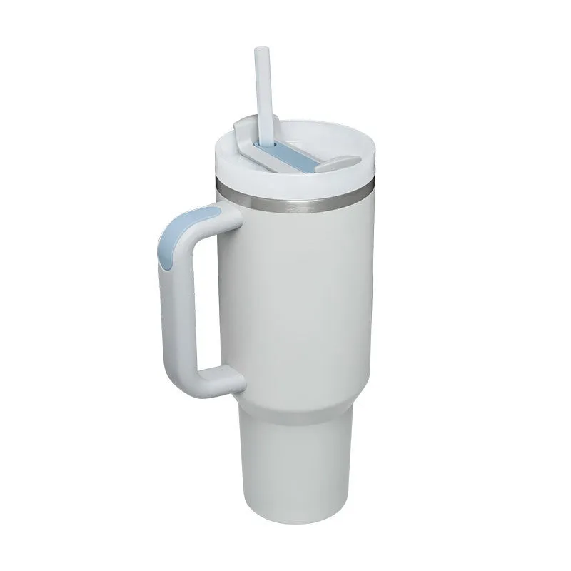 40 oz stainless steel insulated tumbler with a black handle, straw, and grey lid on a wooden table