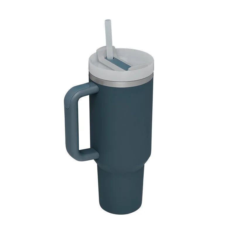 40 oz stainless steel insulated tumbler with a black handle, straw, and grey lid on a wooden table