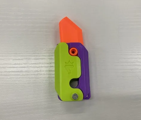 3D printed carrot gravity fidget knife in orange purple green colour, showing blade partly extended from sheath
