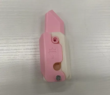 3D printed carrot gravity fidget knife in orange purple green colour, showing blade partly extended from sheath