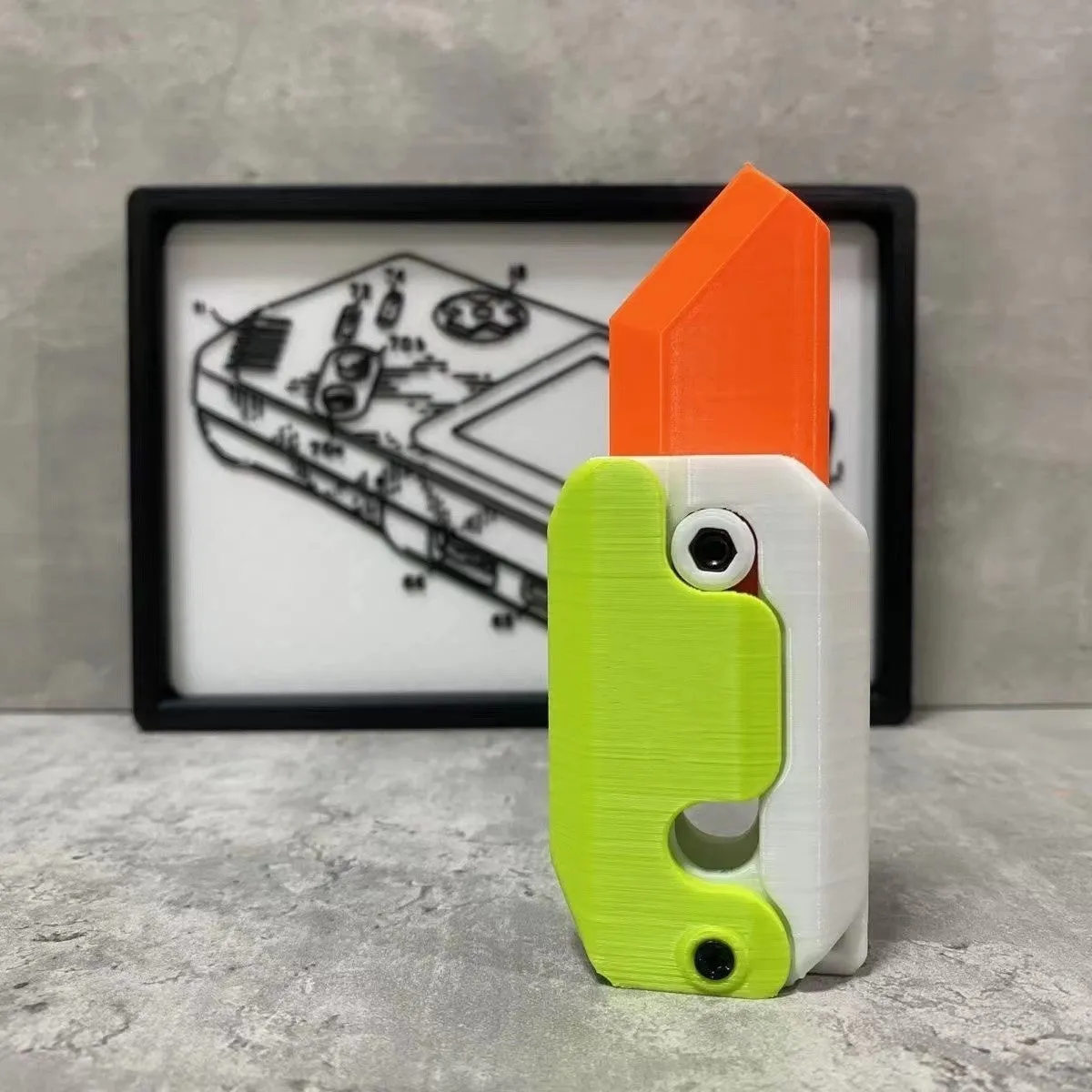 3D printed carrot gravity fidget knife in orange purple green colour, showing blade partly extended from sheath