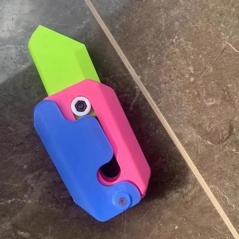 3D printed carrot gravity fidget knife in orange purple green colour, showing blade partly extended from sheath