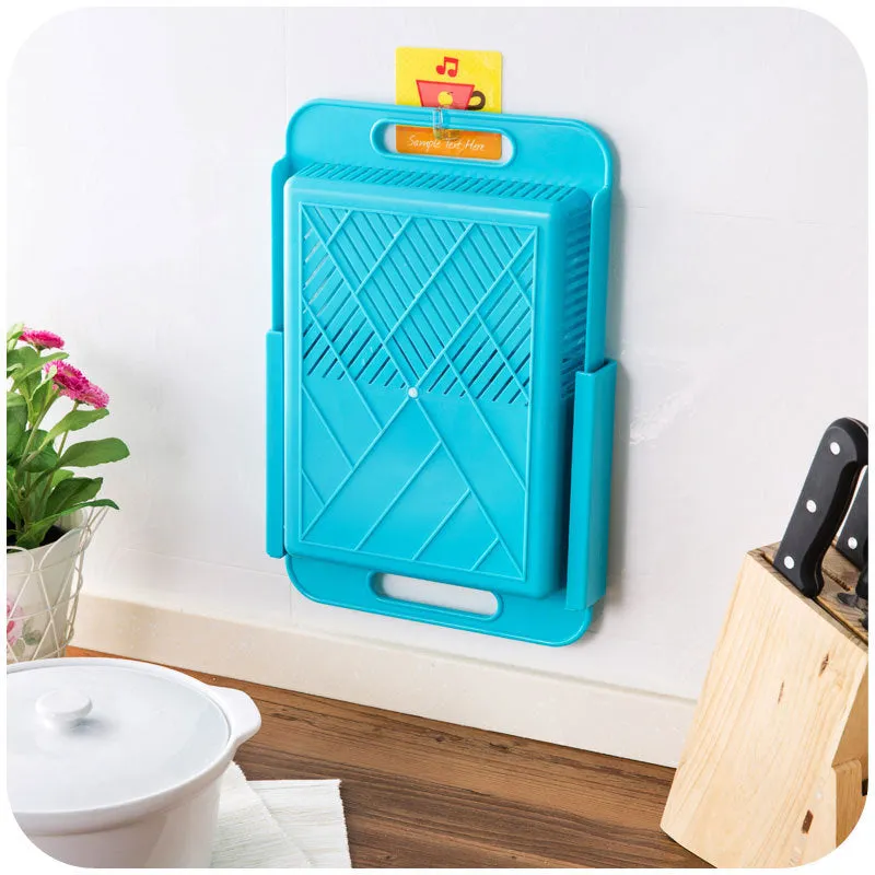 Blue kitchen chopping board with built-in sink drain basket and TPE handle on a counter.