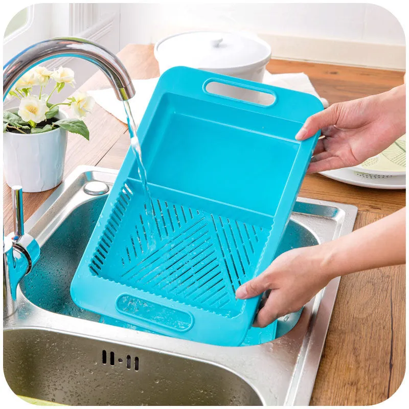 Blue kitchen chopping board with built-in sink drain basket and TPE handle on a counter.