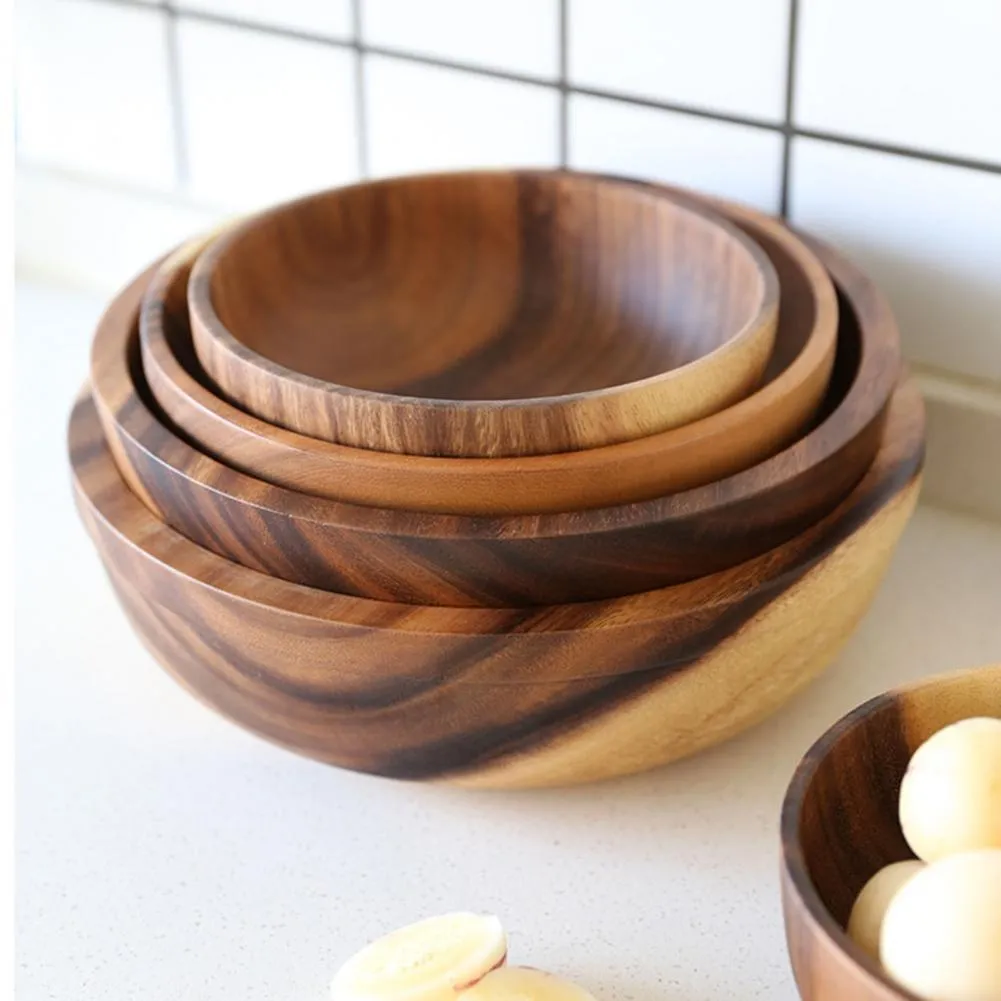 Handmade brown wooden bowl set showing multiple sizes from small to large on wooden table